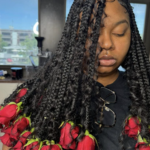 black girl with boho knotless braids with roses on the ends of her hair