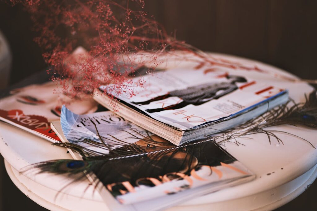 pile of fashion magazines on a small white table