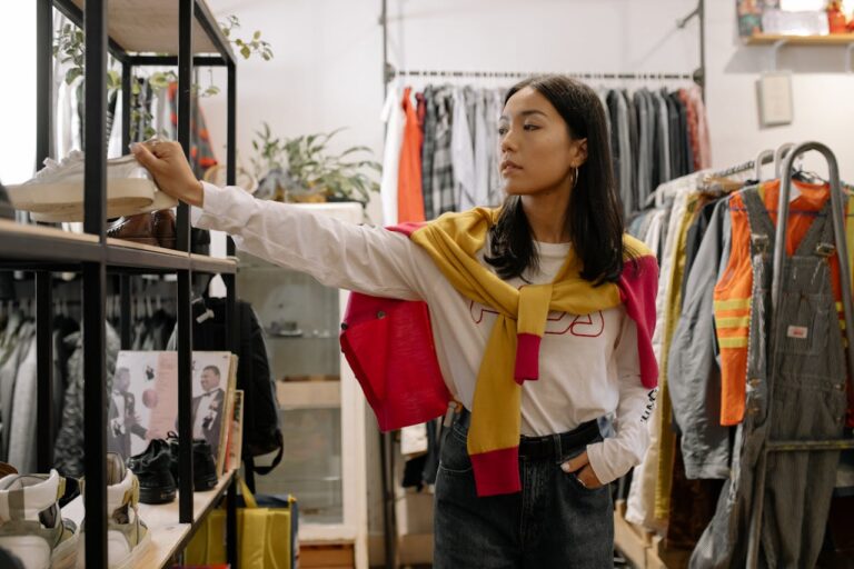 girl is in a thrift store shopping, looking at shoes and clothes in the store